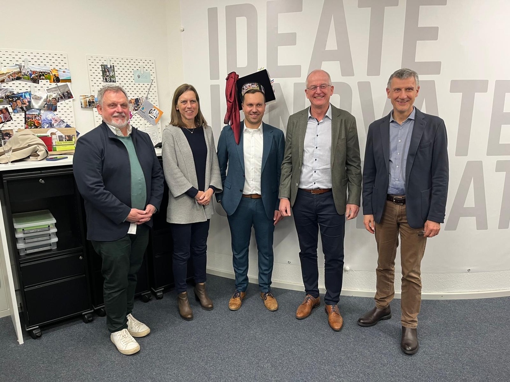 Multiple persons celebrate successfull phd defense